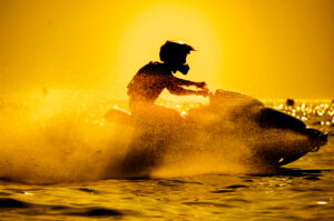 man drive jet ski at sunset.